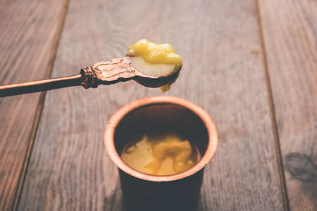 Desi Pure Ghee or clarified butter in glass or Copper container with spoon, selective focusの写真素材