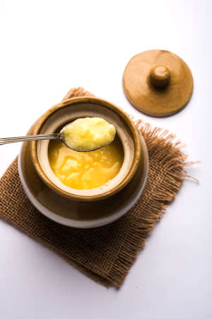 Desi Pure Ghee or clarified butter in glass or Copper container with spoon, selective focusの写真素材