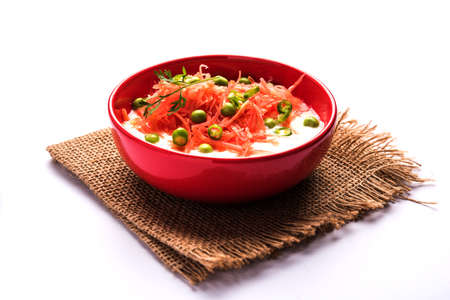 Carrot raita / Gajar  Koshimbir. It a condiment from the Indian subcontinent, made with dahi / curd together with raw / cooked vegetables Gajar / Carrot, green, peas, chilli, corianderの写真素材