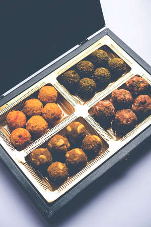 Indian businessman relaxing on beach with cold drinks or laptop, beach ball, talking on phone or with hands spreadの写真素材