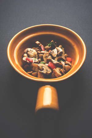 Mushroom Fry or sauteed mushroom or masharoom served in a bowl or in a frying pan over colourful...
