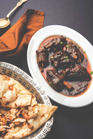 lamb shank or mutton or gosht paya or khoor curry served with indian bread or roti or naanの写真素材