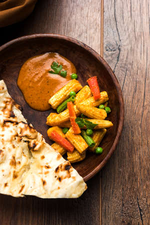 Indian Baby Corn Masala or spicy Baby corn curry served with roti or naan or indian breadの写真素材