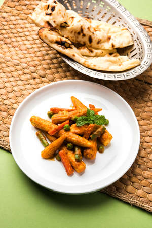 Indian Baby Corn Masala or spicy Baby corn curry served with roti or naan or indian breadの写真素材