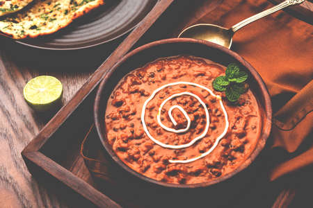 Dal makhani or dal makhni is a popular food from Punjab / India made using  whole black lentil, red kidney beans, butter and cream and served with garlic naan or Indian bread or rotiの写真素材