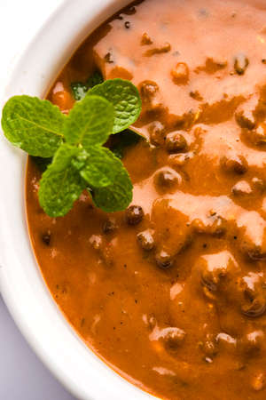 Dal makhani or dal makhni is a popular food from Punjab / India made using  whole black lentil, red kidney beans, butter and cream and served with garlic naan or Indian bread or rotiの写真素材