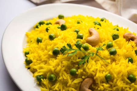 Basmati Rice Pilaf or pulav with Peas, or vegetable rice using green peas also known as matar pulav, with added yellow colour, served with plain dalの写真素材
