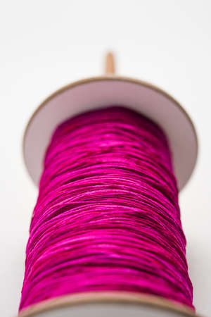 Wooden Spool or chakri/reel/fikri with pink or white thread, isolated over white background