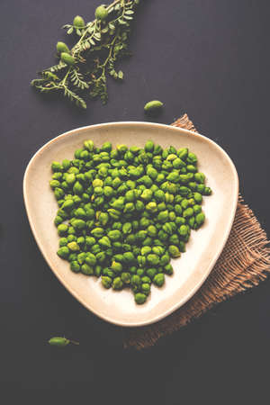Fresh Green Chickpeas or Chick peas also known as harbara or harbhara in hindi and Cicer is scientific name, served in a wooden bowl or plate. selective focusの写真素材