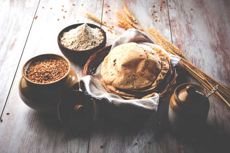indian bread / Chapati / Fulka / Gehu Roti with wheat grains in background. It's a Healthy fiber rich traditional North/South Indian food, selective focusの写真素材