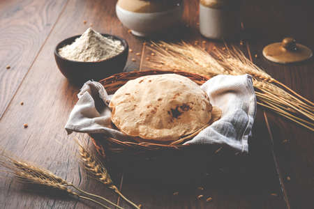 indian bread / Chapati / Fulka / Gehu Roti with wheat grains in background. It's a Healthy fiber rich traditional North/South Indian food, selective focusの写真素材