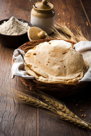indian bread / Chapati / Fulka / Gehu Roti with wheat grains in background. It's a Healthy fiber rich traditional North/South Indian food, selective focusの写真素材