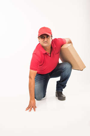 Delivery Concept - Portrait of Happy Indian or delivery man in red or green uniform walking or...