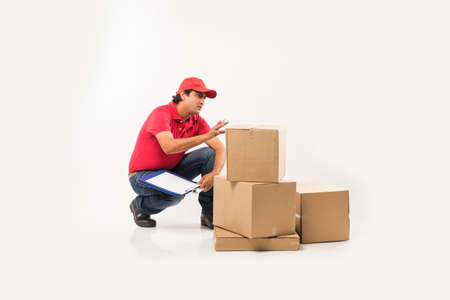 Delivery Concept - Portrait of Happy Indian or delivery man in red or green uniform walking or...