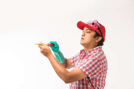 Indian electrician engineer in action with wire cutter, drilling machine etc, standing isolated over white backgroundの写真素材