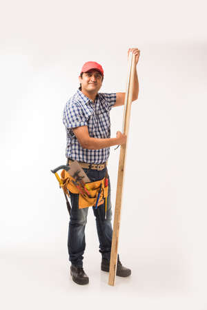 Handsome Indian Carpenter or wood worker in action, isolated over white backgroundの写真素材