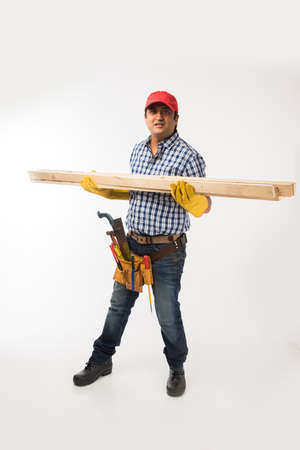Handsome Indian Carpenter or wood worker in action, isolated over white background