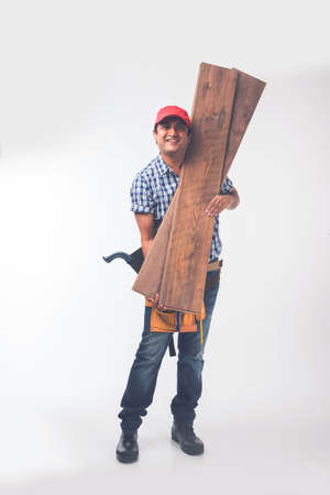 Handsome Indian Carpenter or wood worker in action, isolated over white backgroundの写真素材