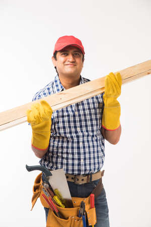 Handsome Indian Carpenter or wood worker in action, isolated over white backgroundの写真素材