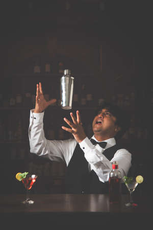Asian Indian Bartender making  cocktail in restaurantの写真素材