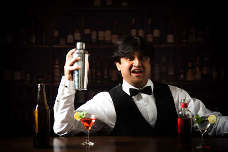 Asian Indian Bartender making  cocktail in restaurantの写真素材