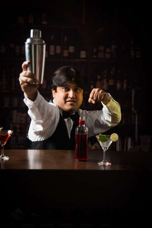 Asian Indian Bartender making  cocktail in restaurantの写真素材