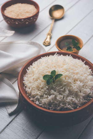 Cooked plain white basmati rice in terracotta bowl over plain or wooden backgroundの写真素材