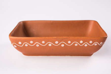 Empty terracotta serving bowl or brown clay soup bowl isolated on whiteの写真素材