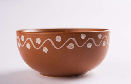 Empty terracotta serving bowl or brown clay soup bowl isolated on white