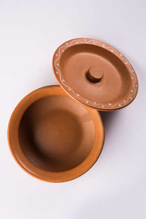 Empty terracotta serving bowl or brown clay soup bowl isolated on whiteの写真素材