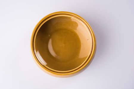 Empty yellow ceramic serving bowl, isolated over white or gray backgroundの写真素材