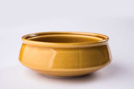 Empty yellow ceramic serving bowl, isolated over white or gray backgroundの写真素材