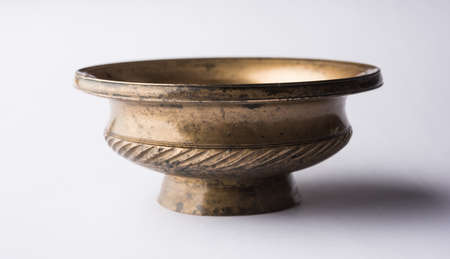 Empty rustic or antique metalic serving bowl, isolated over white or gray backgroundの写真素材