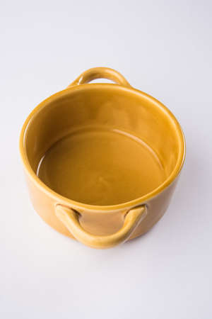 Empty yellow ceramic serving bowl, isolated over white or gray backgroundの写真素材