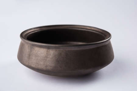 Empty black ceramic serving bowl, isolated over white or gray backgroundの写真素材