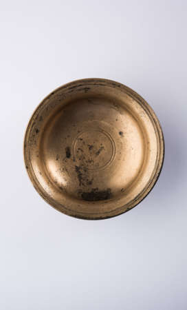 Empty rustic or antique metalic serving bowl, isolated over white or gray backgroundの写真素材