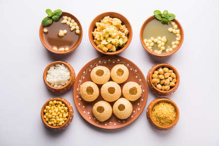 Pani Puri is Indian chat item served in a terracotta bowls and plate