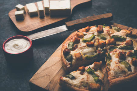 Indian Paneer Pizza with fresh cottage Cheese cubes and white sauceの写真素材