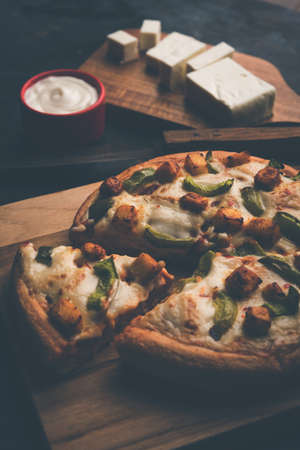 Indian Paneer Pizza with fresh cottage Cheese cubes and white sauceの写真素材