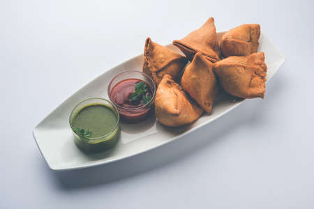 Veg Samosa is a triangle shape pakora stuffed with Aloo sabji, served with green chutney and tomato...