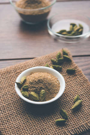 elaichi or Cardamom powder in bowl or heap over moody background with pods. selective focusの写真素材