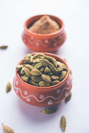 elaichi or Cardamom powder in bowl or heap over moody background with pods. selective focusの写真素材