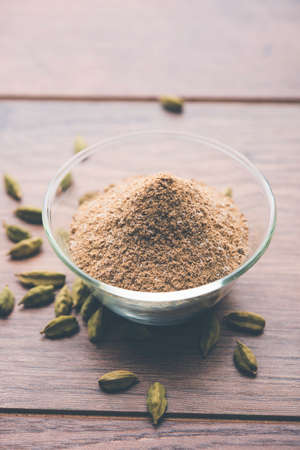 elaichi or Cardamom powder in bowl or heap over moody background with pods. selective focusの写真素材