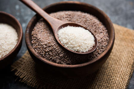 Psyllium husk or isabgol which is fiber derived from the seeds of Plantago ovata, mainly found in India. Served in a bowl over moody background. selective focusの写真素材