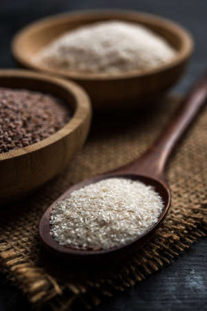 Psyllium husk or isabgol which is fiber derived from the seeds of Plantago ovata, mainly found in India. Served in a bowl over moody background. selective focusの写真素材