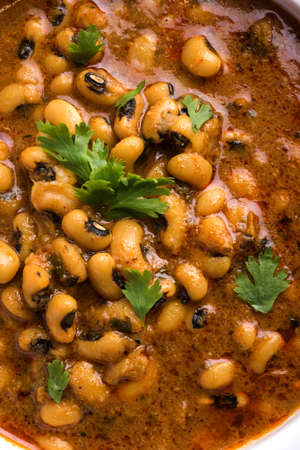 Black Eyed Kidney Beans Curry or Chawli chi usal / masala, served in a ceramic bowl over moody...