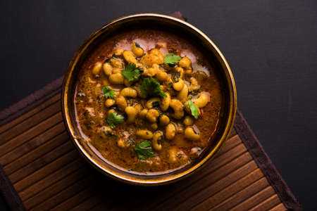 Black Eyed Kidney Beans Curry or Chawli chi usal / masala, served in a ceramic bowl over moody...