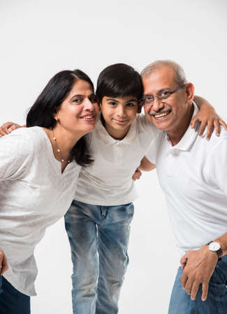 Indian/asian senior couple with grandson, isolated over whiteの写真素材