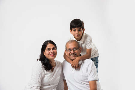 Indian/asian senior couple with grandson, isolated over white