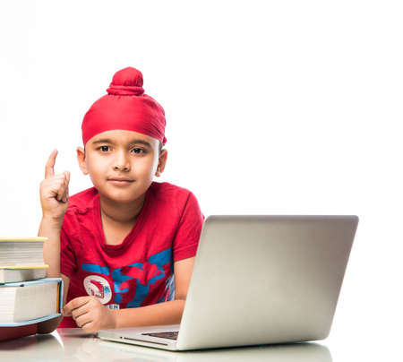 Sikh Indian kid/boy studying using laptop or playing games
